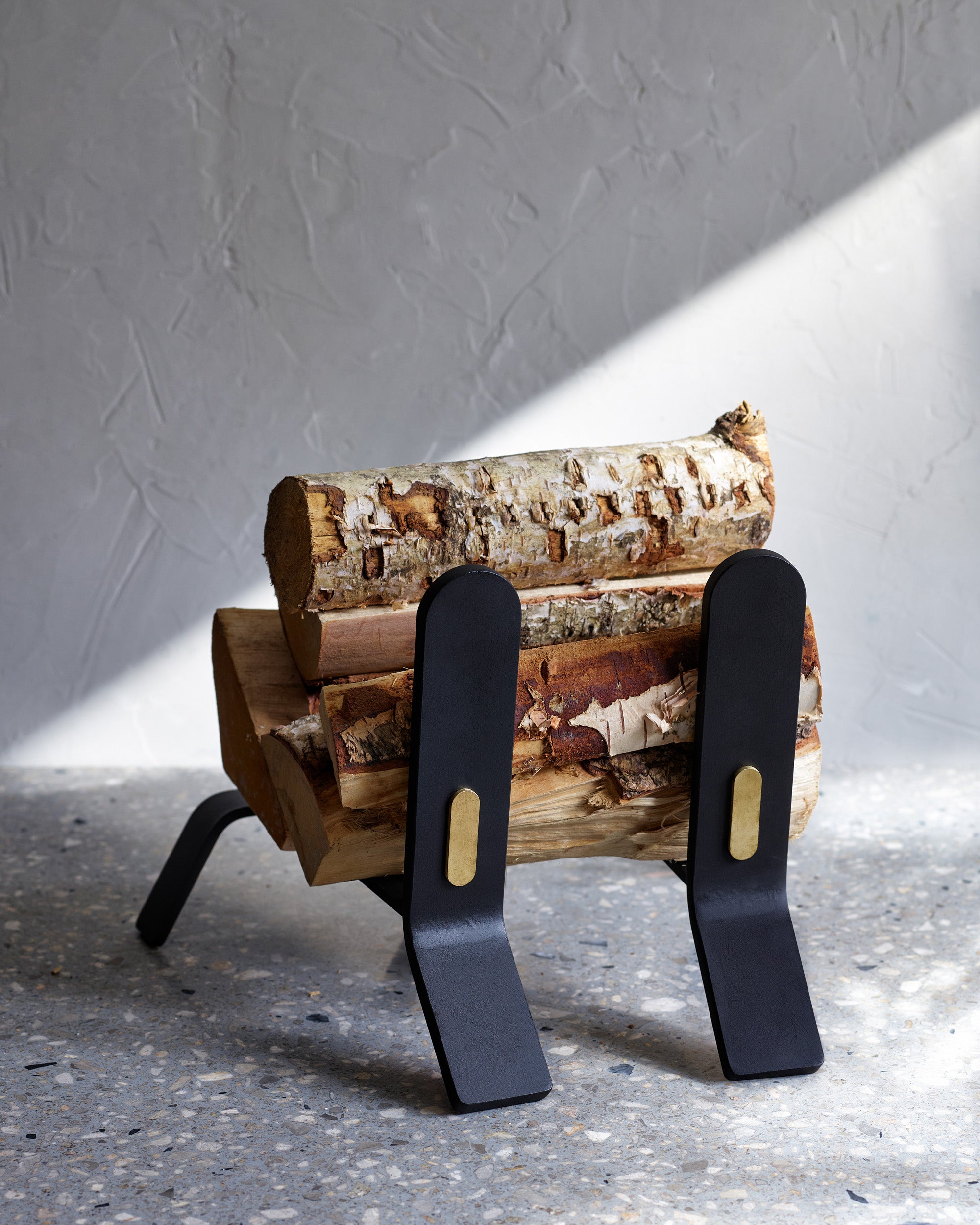 Wooden log holder with logs on a gray surface