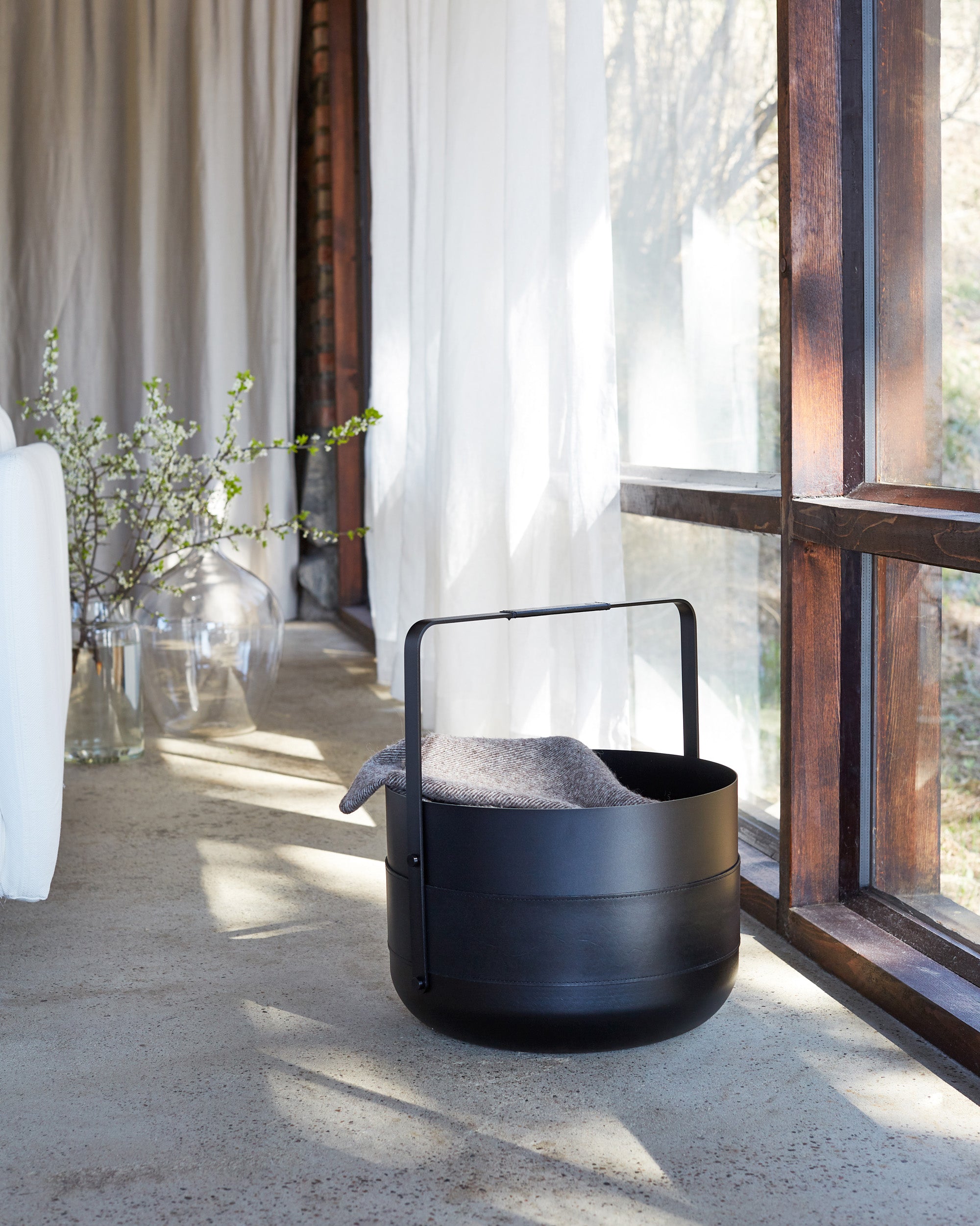 Eldvarm Emma Basket - Noir in a styled interior setting