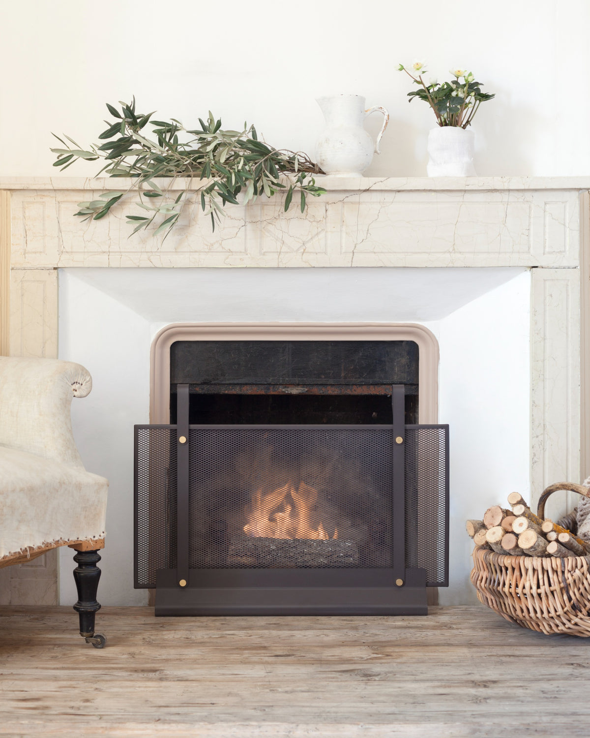 Fireplace with roaring fire, decorative screen in front