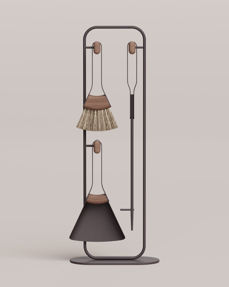 Decorative broom and dustpan set on a stand against a beige background