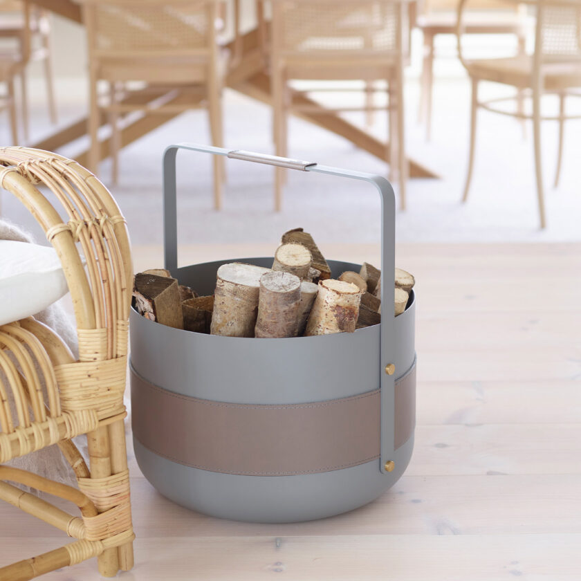 Emma Basket in Paris (medium grey powder-coated steel, grey leather and brass details) filled with firewood.