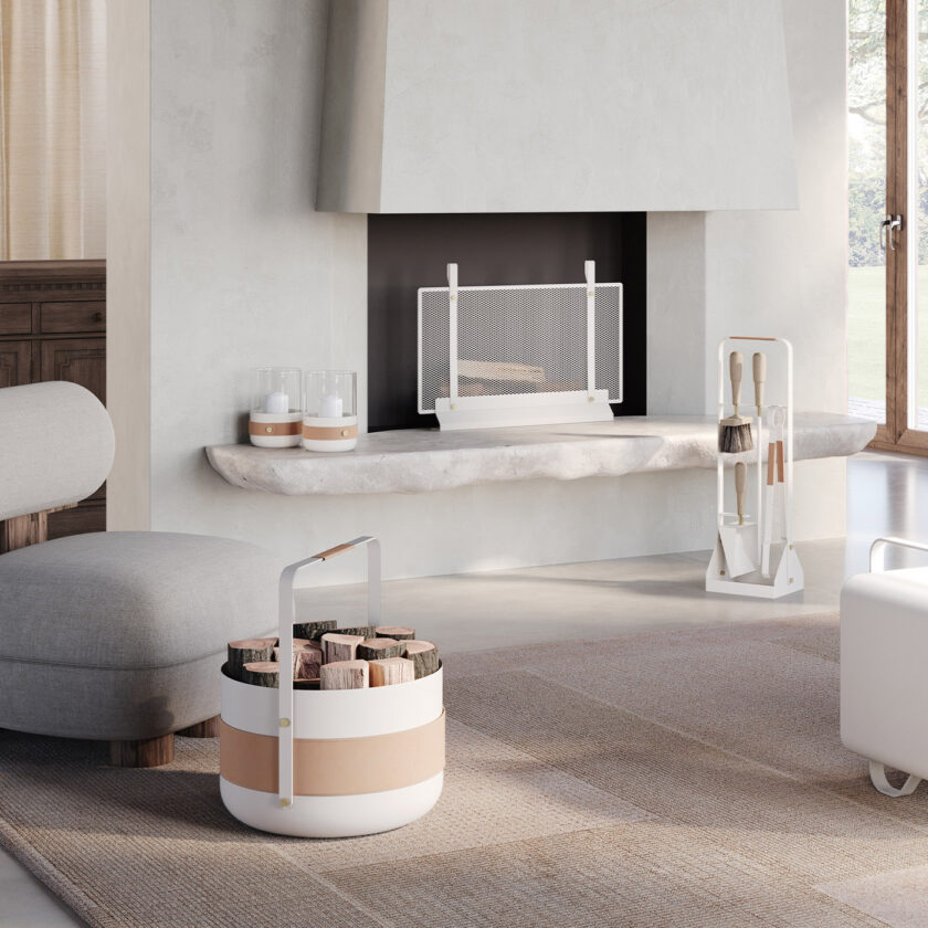 Emma Basket in Blanc combines cream white powder-coated steel, beige leather and brass details, in a living room with a fireplace along with other products in the same colour.