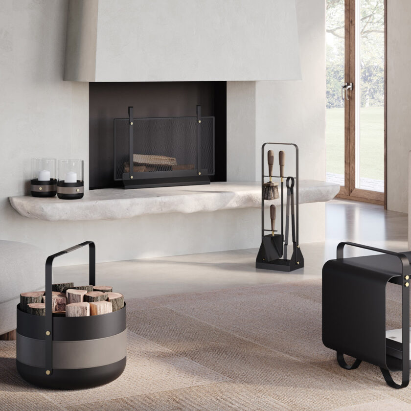 Emma Companion Set in Graphite (charcoal black powder-coated steel, “Ellie” grey leather, walnut wood handles and details in solid brass) in a living room with a fireplace and other products in the same colour.