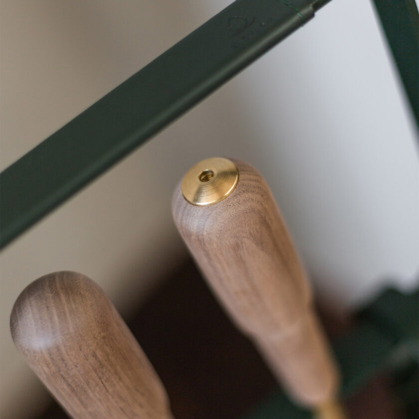Close up of the top of the blow poker, one of the tools in the Emma Companion Set in Forêt (British racing green powder-coated steel, “Forêt” green leather, walnut wood handles and details in solid brass).