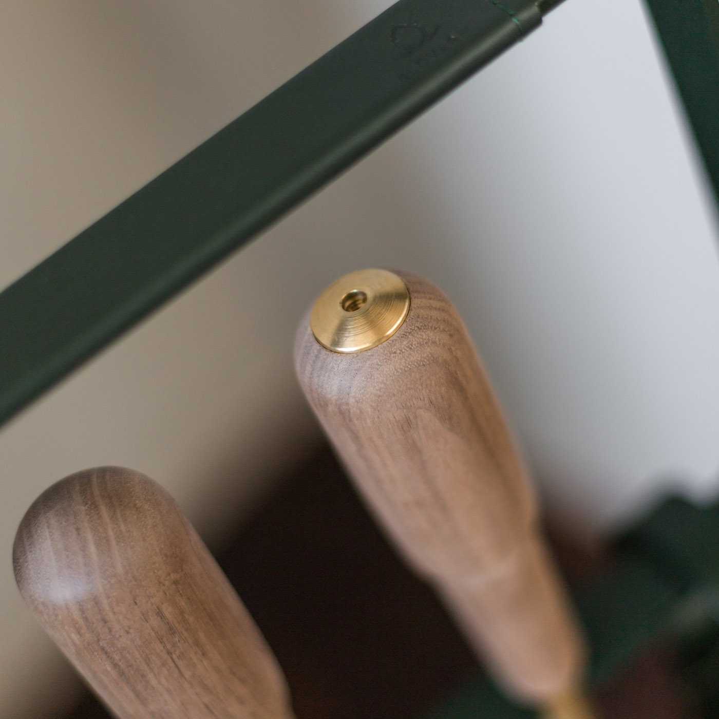 Close up of the top of the blow poker, one of the tools in the Emma Companion Set in Forêt (British racing green powder-coated steel, “Forêt” green leather, walnut wood handles and details in solid brass).