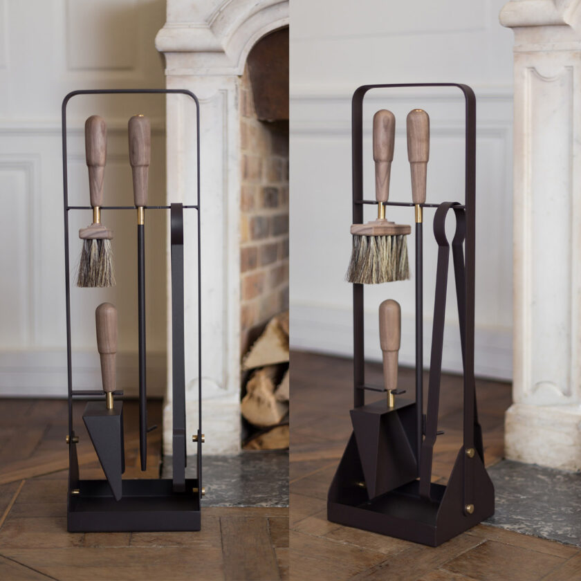 Emma Companion Set in Classique (dark warm grey powder-coated steel, walnut wood handles and details in solid brass) next to a fireplace and shown from two angles.