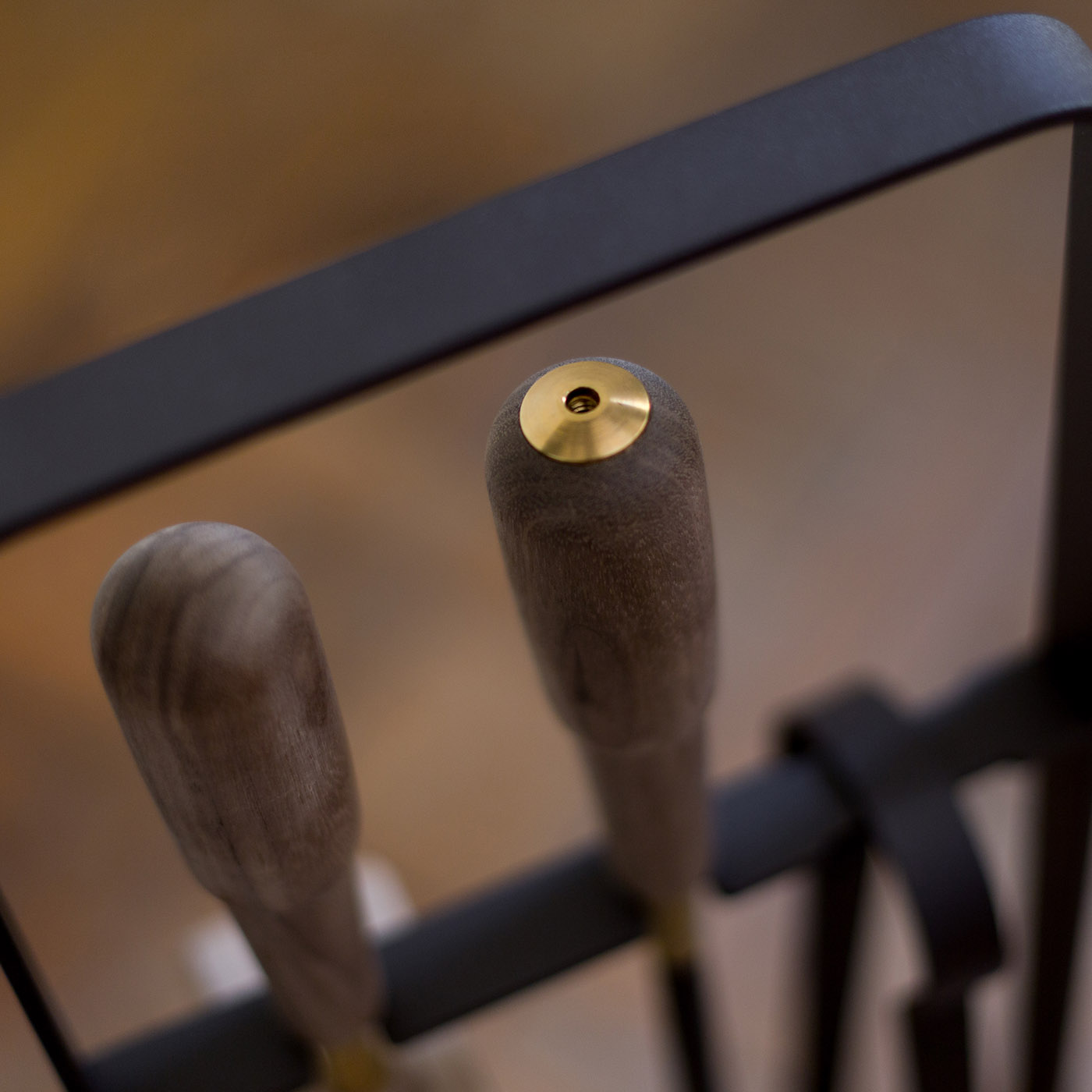 Close up of handles of the Emma Companion Set in Classique (dark warm grey powder-coated steel, walnut wood handles and details in solid brass).