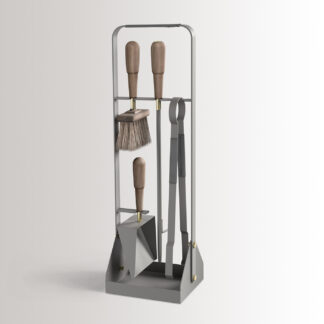 Emma Companion Set in Paris combines medium grey powder-coated steel, with "Ellie” grey leather, walnut wood handles and details in solid brass.