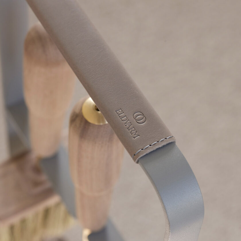 Close up of the leather of Emma Companion Set in Paris (medium grey powder-coated steel, "Ellie” grey leather, walnut wood handles and details in solid brass).