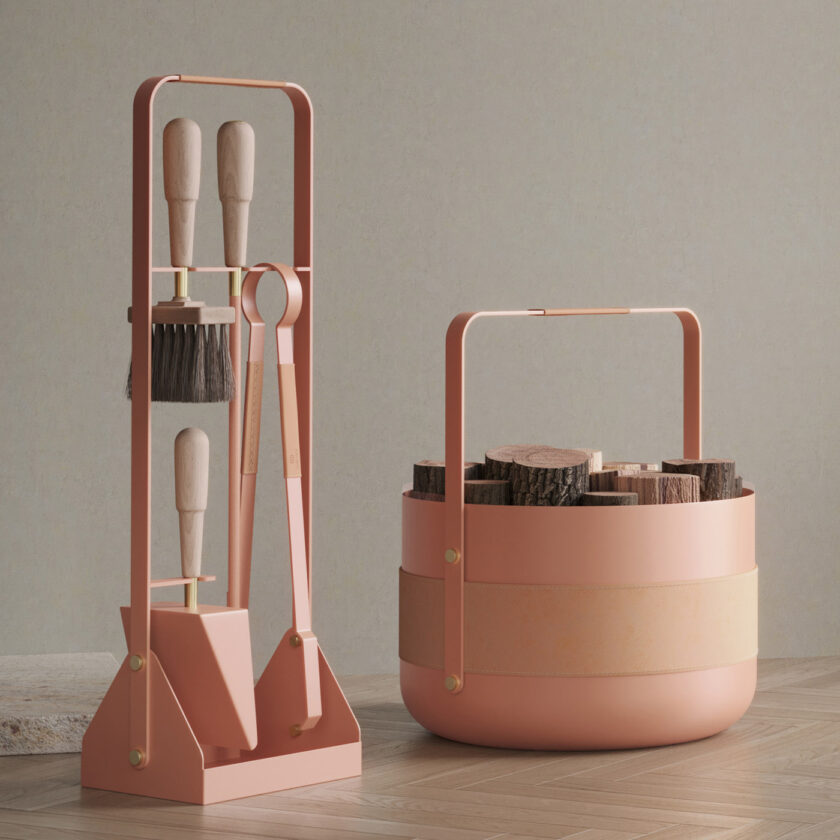 Emma Companion Set in BonBon (peachy pink powder-coated steel, “Naturel” beige leather, beech wood handles and details in solid brass) next to a basket in the same colour.