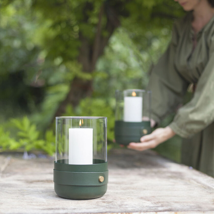 Emma Lantern in Forêt (dark green powder-coated steel, “Forêt” green leather, hand blown glass and brass details) outdoors.