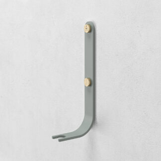 Emma Wall Hook in Lichen is made of light green grey powder-coated steel, with brass details.
