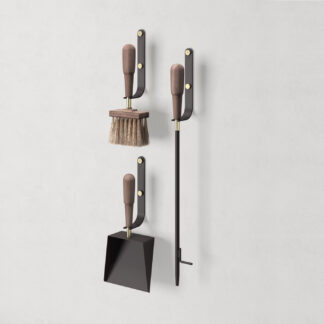Emma Wall in Classique (dark warm grey powder-coated steel, walnut wood and brass details) includes 3 wall hooks, a blow poker, and a shovel and brush.