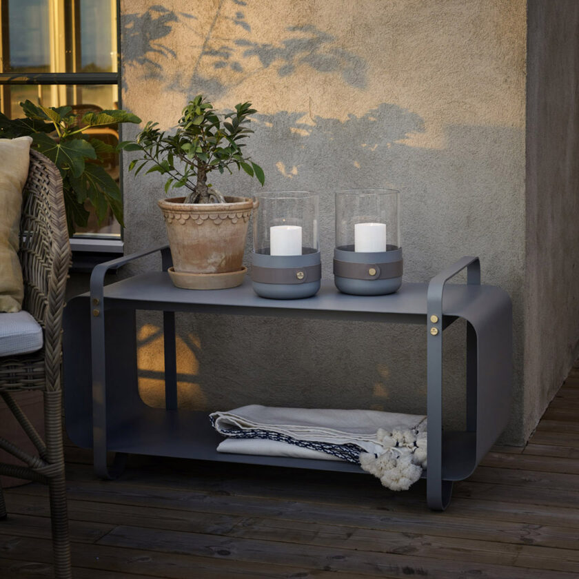 Ninne Bench Outdoor in Paris (medium grey powder-coated steel) with a pair of Emma Lanterns in Paris (medium grey powder-coated steel, “Ellie” grey leather, hand blown glass and brass details).