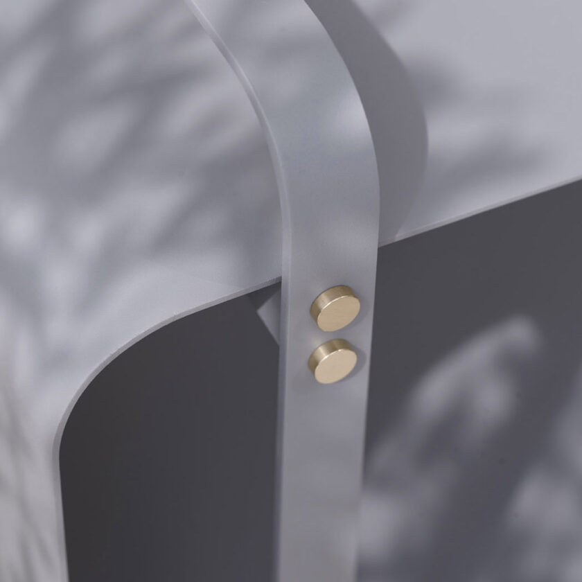 Detail shot of Ninne Bench in Paris (medium grey powder-coated steel) with a focus on brass details.