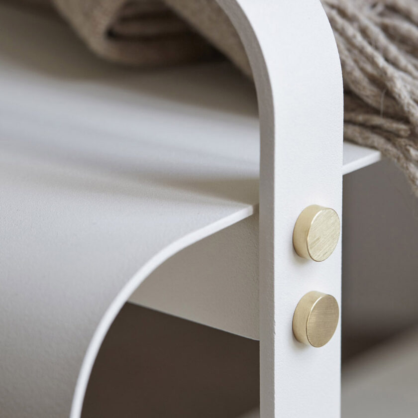 Detail shot of the Ninne Bench in cream white powder-coated steel (Blanc), showing brass details.