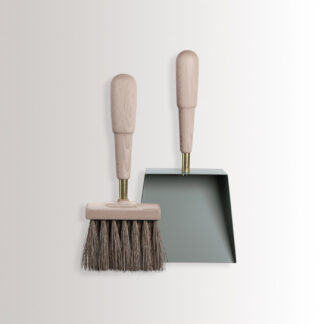 Emma Shovel & Brush in Lichen combines light green grey powder-coated steel, with beech wood and brass details.