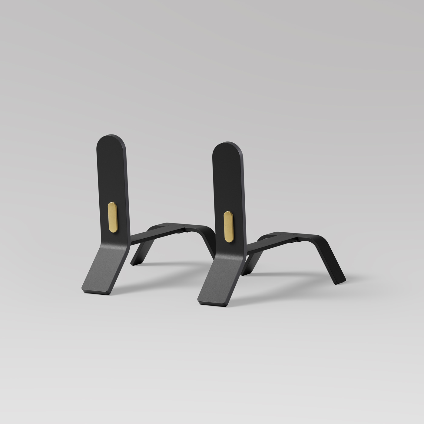 A pair of sleek, black metal stands with gold-colored accents at the center of the vertical supports. The stands have a modern, minimalist design with angular bases and a smooth matte finish, set against a plain light gray background.