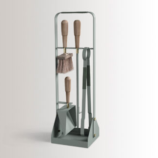 Emma Companion Set in Jardin combines light green powder-coated steel, with “Forêt” green leather, walnut wood handles and details in solid brass.