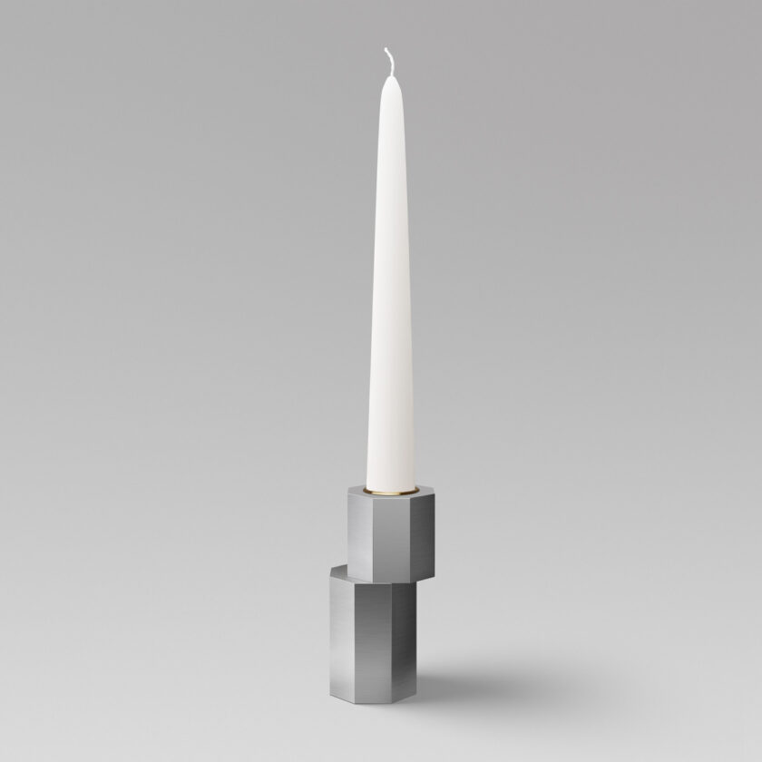 Luca Candle Holder in Lumière (stainless steel) with brass insert and an unlit candle.