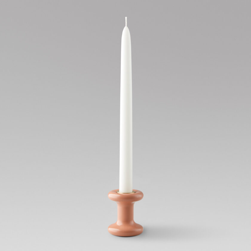 Lucie candle holder short in Bonbon (pink powder-coated steel) with a brass insert and unlit candle.