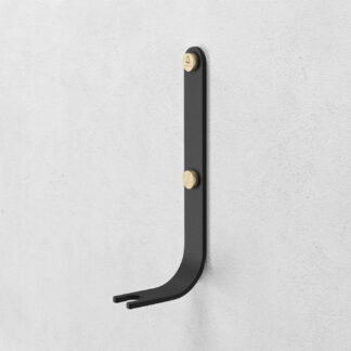 Emma Wall Hook in Graphite is made of charcoal black powder-coated steel, with brass details.