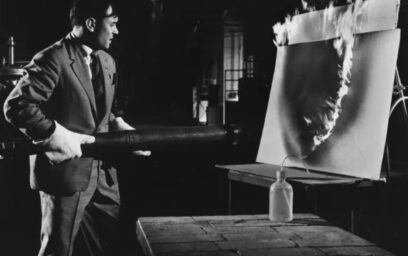 A black and white photo of Artist Yves Klein using creating art with fire.