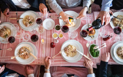 An overhead view of people sitting around a full dining table.