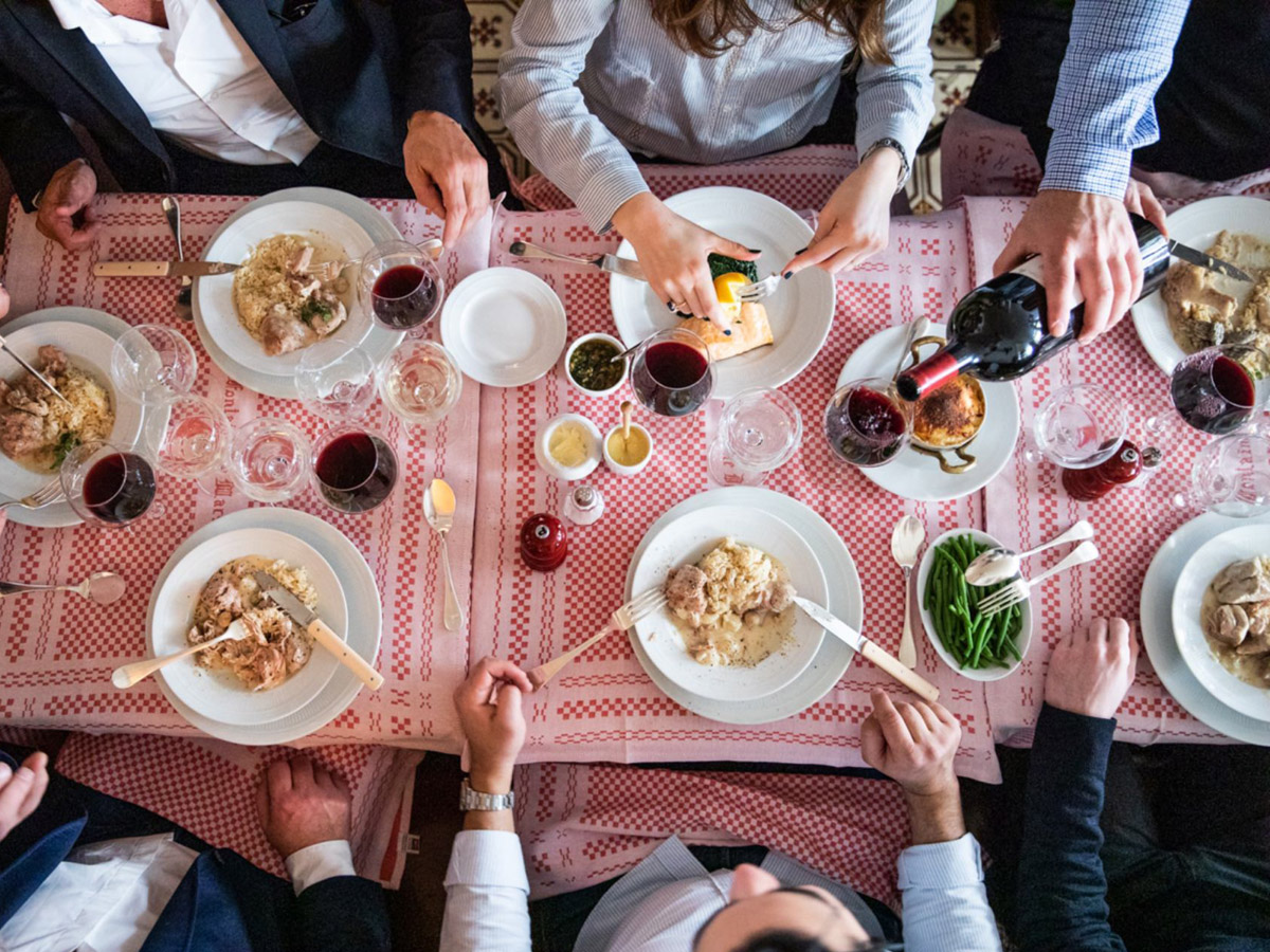 An overhead view of people sitting around a full dining table.