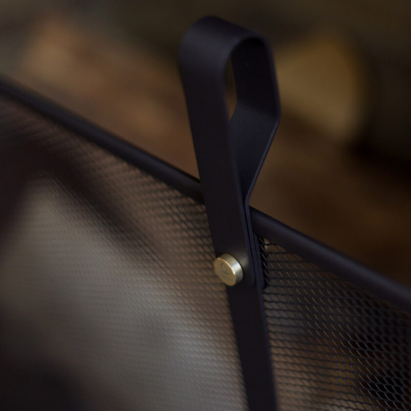 A detail photo of the dark warm grey powder coated steel and solid brass details on the Emma Firescreen Classique.