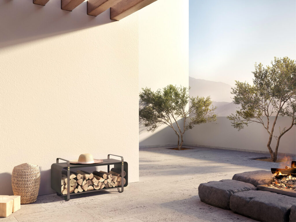 Outdoor Ninne Bench in Classique colour shown in an outdoor setting next to a fire pit
