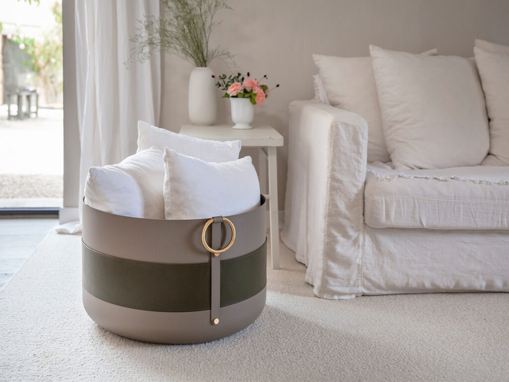 Emma Basket XL holding cushions in a living room, next to a sofa